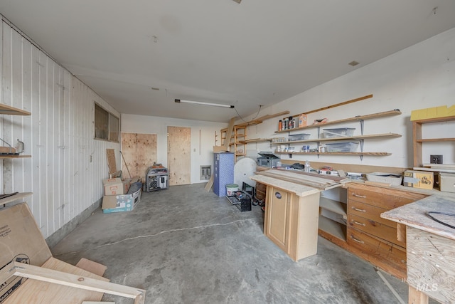 misc room featuring wooden walls and a workshop area