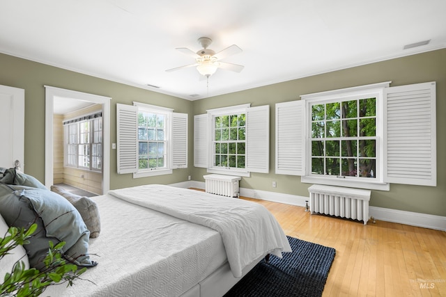 1312 E Warm Springs Ave, Boise, ID 83712 - bedroom with radiator heating unit, baseboards, wood-type flooring, a ceiling fan, and crown molding