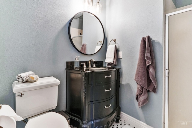bathroom with toilet, vanity, baseboards, and an enclosed shower