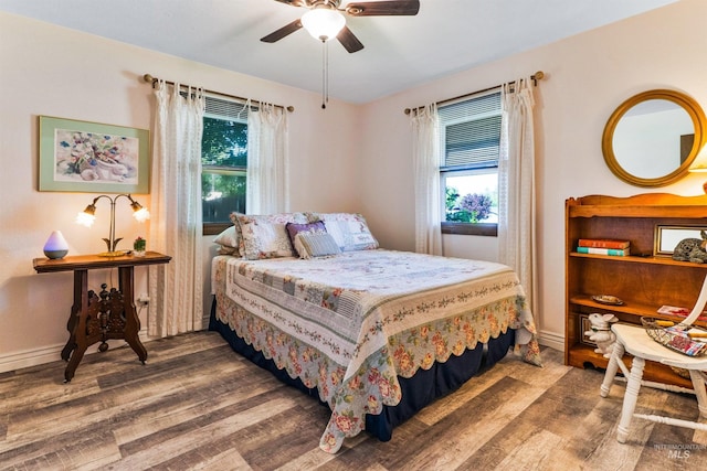 bedroom with wood finished floors, baseboards, and ceiling fan