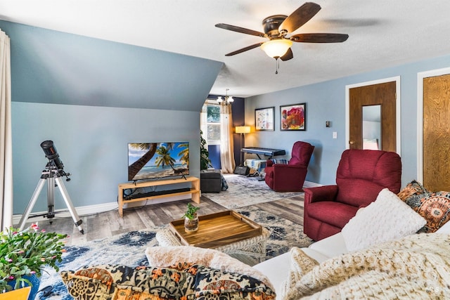 living room featuring wood finished floors, a ceiling fan, baseboards, and a chandelier