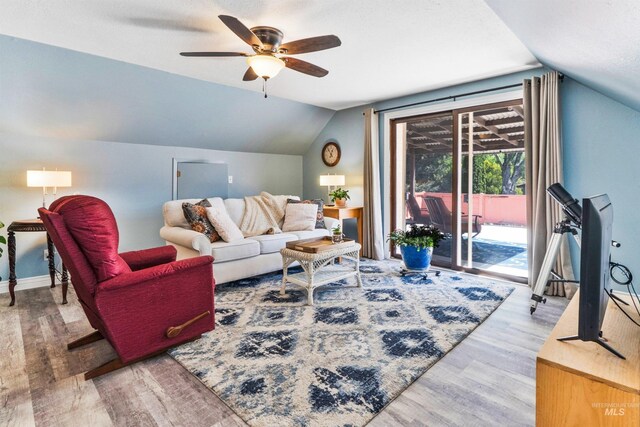 living area with vaulted ceiling, wood finished floors, ceiling fan, and baseboards