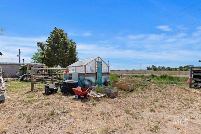 764 NW Beaman St, Mountain Home, ID 83647 - view of yard featuring a greenhouse, a vegetable garden, and an outbuilding