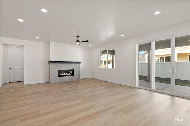 unfurnished living room with baseboards, ceiling fan, recessed lighting, light wood-style flooring, and a fireplace