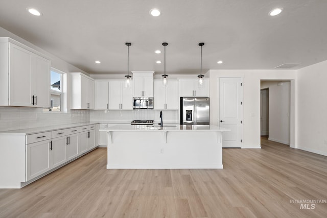 kitchen featuring white cabinetry, light countertops, light wood finished floors, and appliances with stainless steel finishes