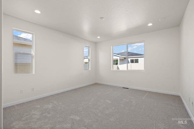 empty room featuring visible vents, recessed lighting, baseboards, and carpet floors