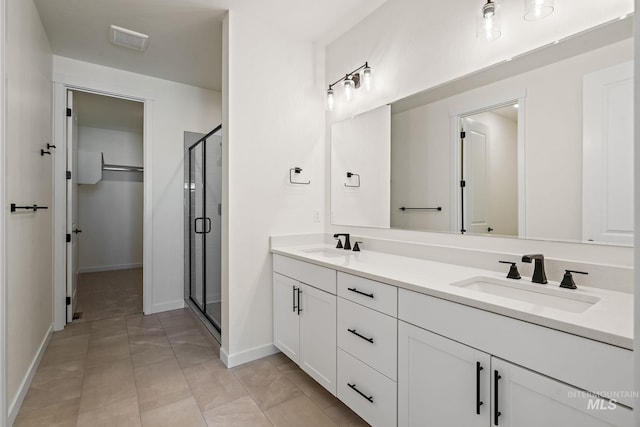 bathroom with a shower stall, double vanity, visible vents, and a sink