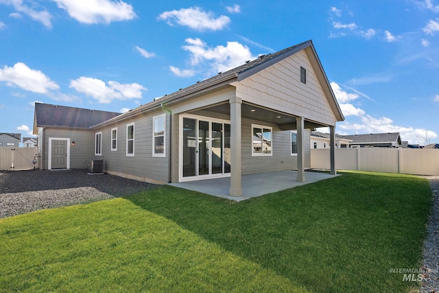 back of house featuring a patio, central AC unit, fence, and a lawn