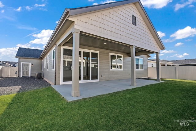 rear view of house featuring a yard, central air condition unit, a patio area, and fence