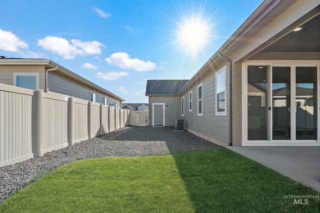 view of yard featuring a patio area, central air condition unit, and a fenced backyard