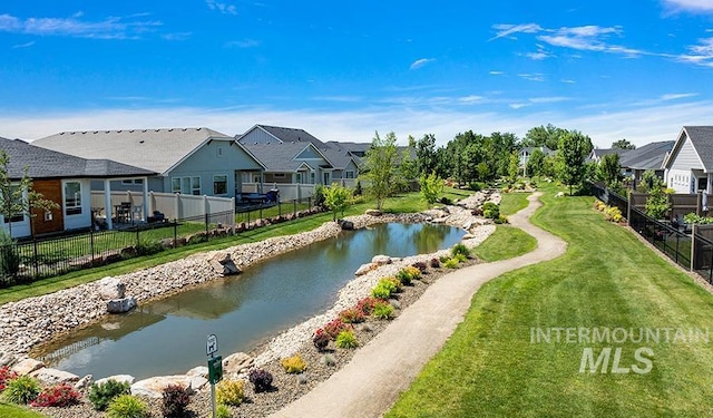 property view of water featuring fence and a residential view