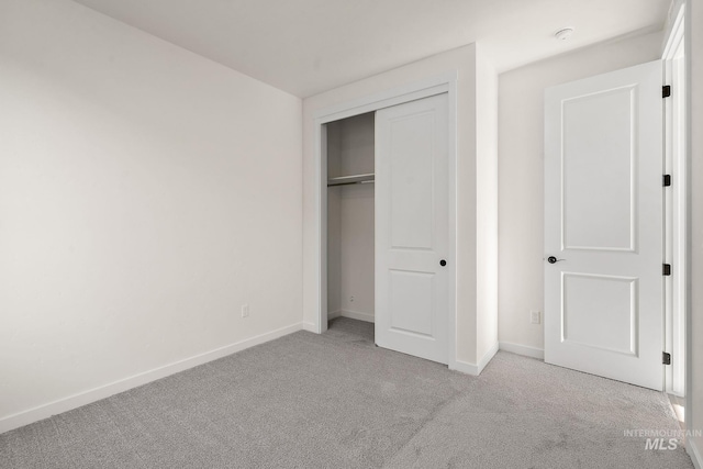 unfurnished bedroom featuring a closet, baseboards, and carpet flooring