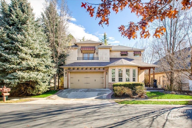 traditional home featuring an attached garage, stucco siding, driveway, and a balcony