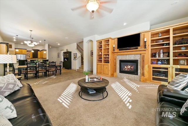 living area with recessed lighting, light carpet, a tile fireplace, and ceiling fan with notable chandelier