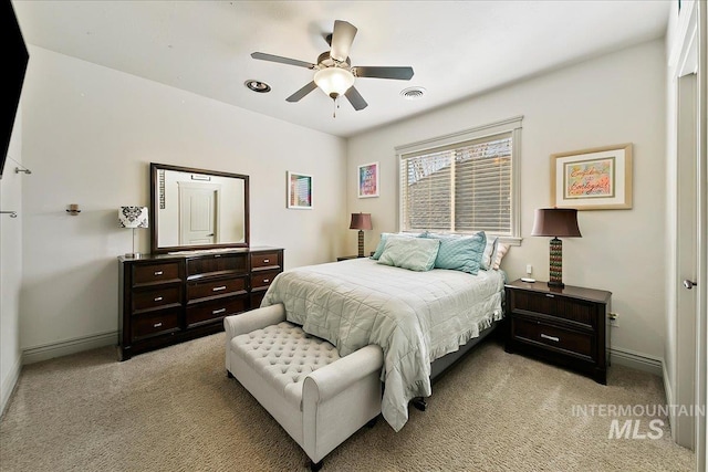 bedroom with light carpet, baseboards, a ceiling fan, and visible vents
