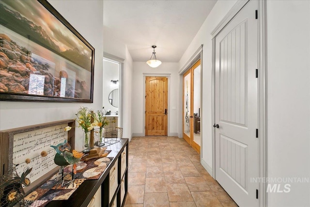 doorway to outside with baseboards and stone finish floor