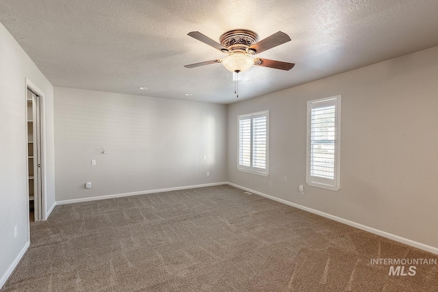 unfurnished room with a textured ceiling, carpet, a ceiling fan, and baseboards