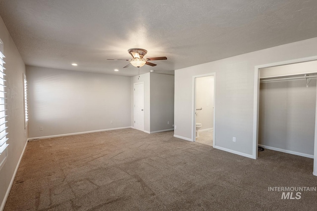 unfurnished bedroom featuring baseboards, ensuite bathroom, carpet, a textured ceiling, and recessed lighting