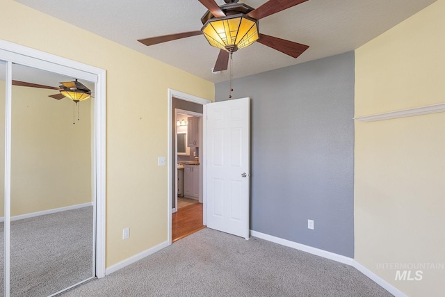 unfurnished bedroom with a ceiling fan, baseboards, and carpet flooring