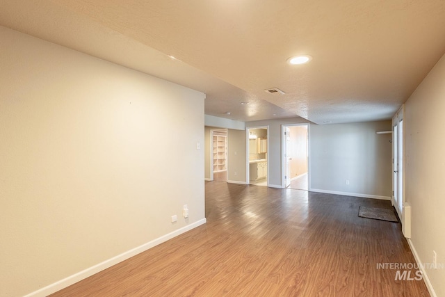 empty room featuring visible vents, baseboards, and wood finished floors