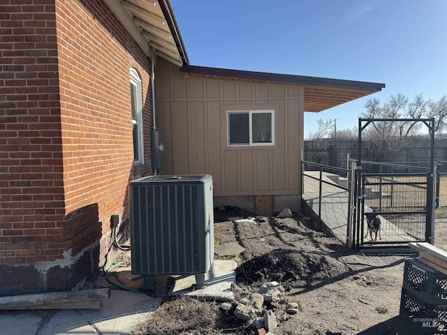 145 N Lincoln, Oakley, ID 83346 - view of property exterior featuring cooling unit, fence, brick siding, and a gate