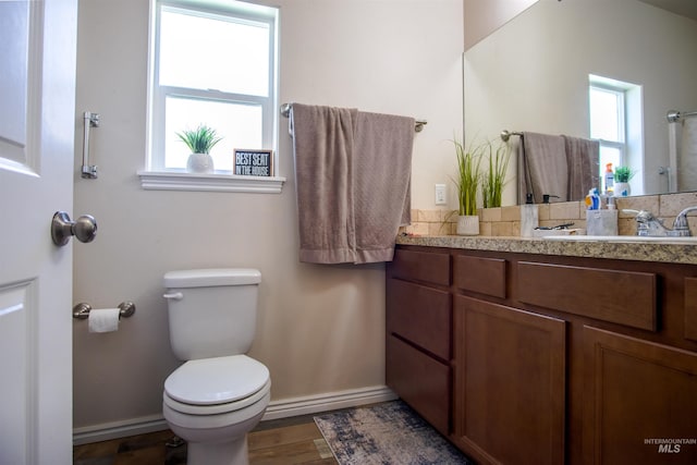 bathroom featuring hardwood / wood-style floors, vanity, toilet, and a healthy amount of sunlight