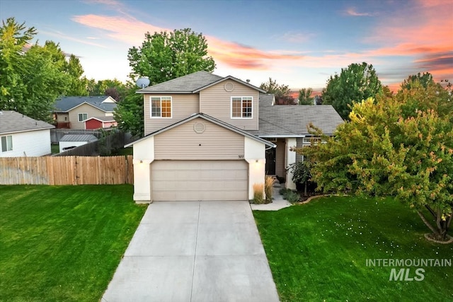 view of front facade with a garage, driveway, a lawn, and fence