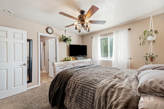 bedroom featuring a textured ceiling, a ceiling fan, and light colored carpet