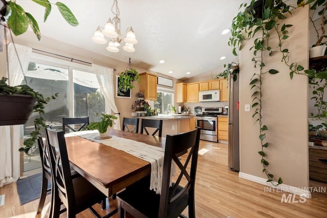 dining space with baseboards, vaulted ceiling, light wood-type flooring, a chandelier, and recessed lighting