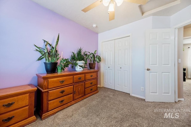 bedroom with ceiling fan, a closet, baseboards, and light colored carpet