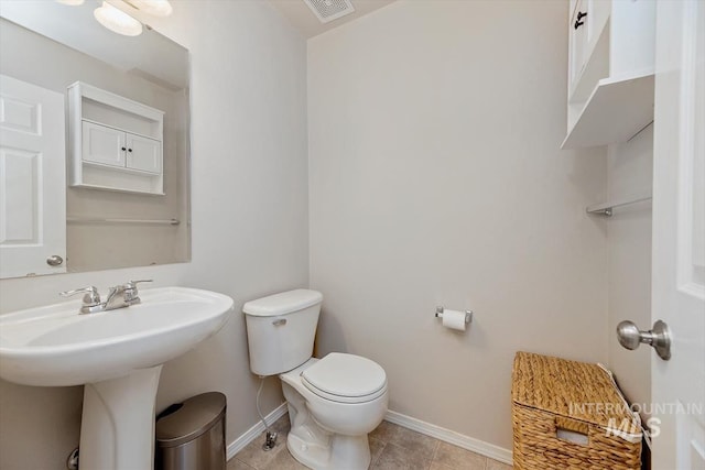 bathroom with tile patterned flooring, baseboards, visible vents, and toilet