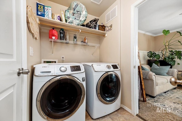 washroom with light tile patterned floors, washing machine and dryer, laundry area, visible vents, and crown molding