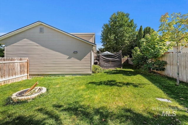 view of yard featuring an outdoor fire pit and a fenced backyard