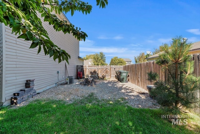 view of yard with a fenced backyard and central AC unit