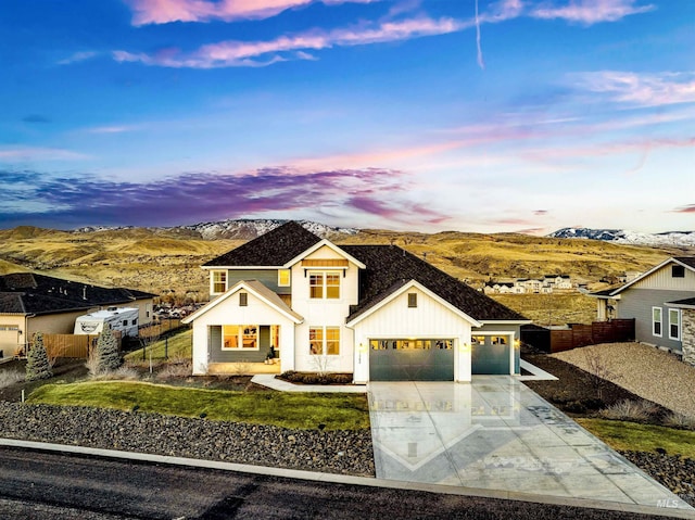 modern farmhouse style home with board and batten siding, fence, driveway, and an attached garage