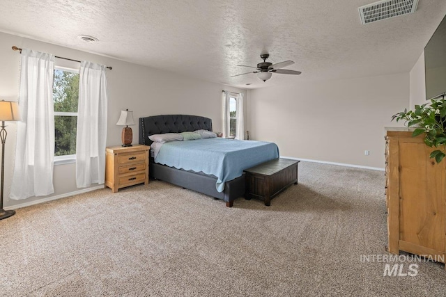 12339 W Foxhaven St, Star, ID 83669 - bedroom featuring light carpet, multiple windows, a textured ceiling, and ceiling fan