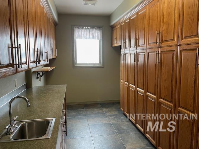 2655 13th St, Clarkston, WA 99403 - laundry area featuring a sink, baseboards, and dark tile patterned floors