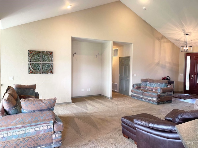 carpeted living room featuring a notable chandelier and high vaulted ceiling