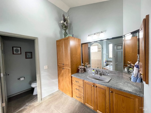 bathroom featuring tile patterned floors, vanity, toilet, and high vaulted ceiling