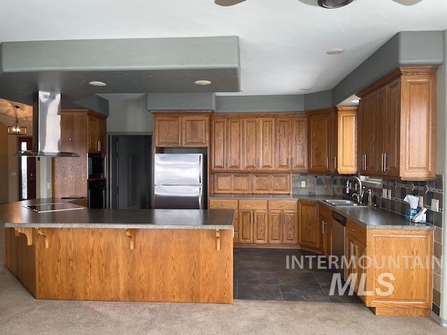 2655 13th St, Clarkston, WA 99403 - kitchen with freestanding refrigerator, wall chimney range hood, a sink, a peninsula, and black electric stovetop