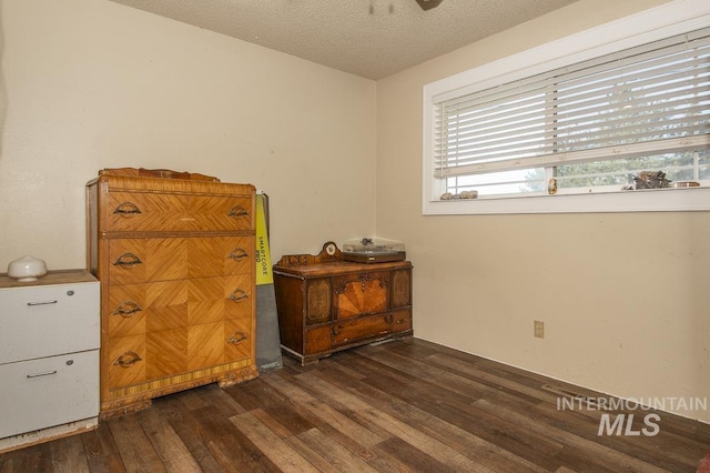 bedroom with a textured ceiling and dark wood-type flooring