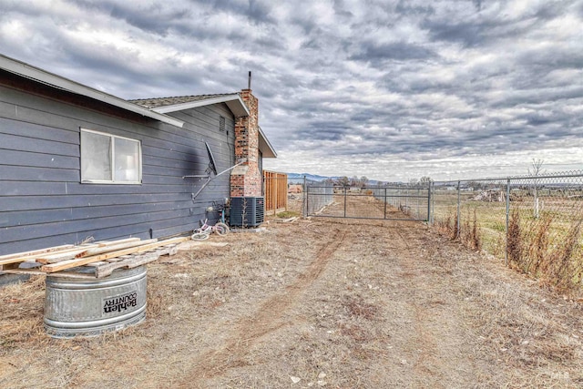 view of yard with central AC, a gate, and fence