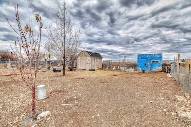 view of yard featuring a fenced backyard, exterior structure, an outbuilding, and a storage shed