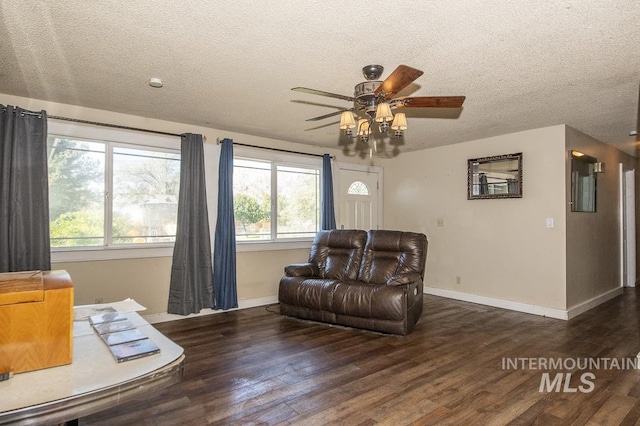 living room featuring a ceiling fan, a textured ceiling, and a wealth of natural light