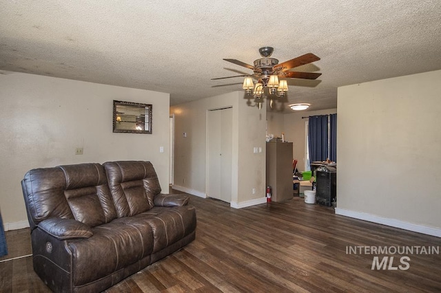 living area featuring a textured ceiling, baseboards, a ceiling fan, and wood finished floors