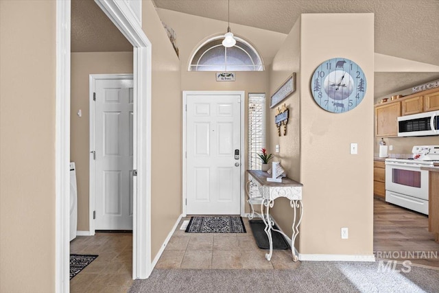 16702 Frisco Ave, Caldwell, ID 83607 - foyer with lofted ceiling, a textured ceiling, tile patterned flooring, and baseboards