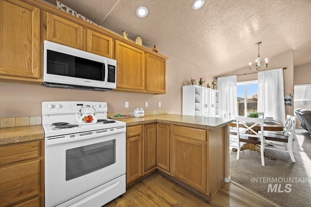 16702 Frisco Ave, Caldwell, ID 83607 - kitchen with white appliances, a chandelier, lofted ceiling, wood finished floors, and a textured ceiling