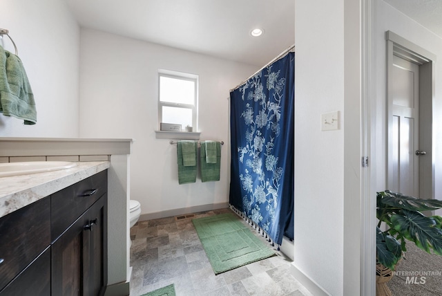 2026 Kelly Dr, Payette, ID 83661 - full bathroom with toilet, vanity, curtained shower, stone finish flooring, and recessed lighting