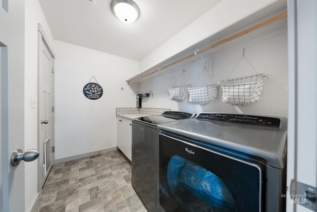 2026 Kelly Dr, Payette, ID 83661 - laundry room with washer and dryer, baseboards, cabinet space, and stone finish floors