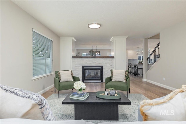 1499 E Sicily St, Meridian, ID 83642 - living room with a stone fireplace, wood finished floors, stairs, and a chandelier